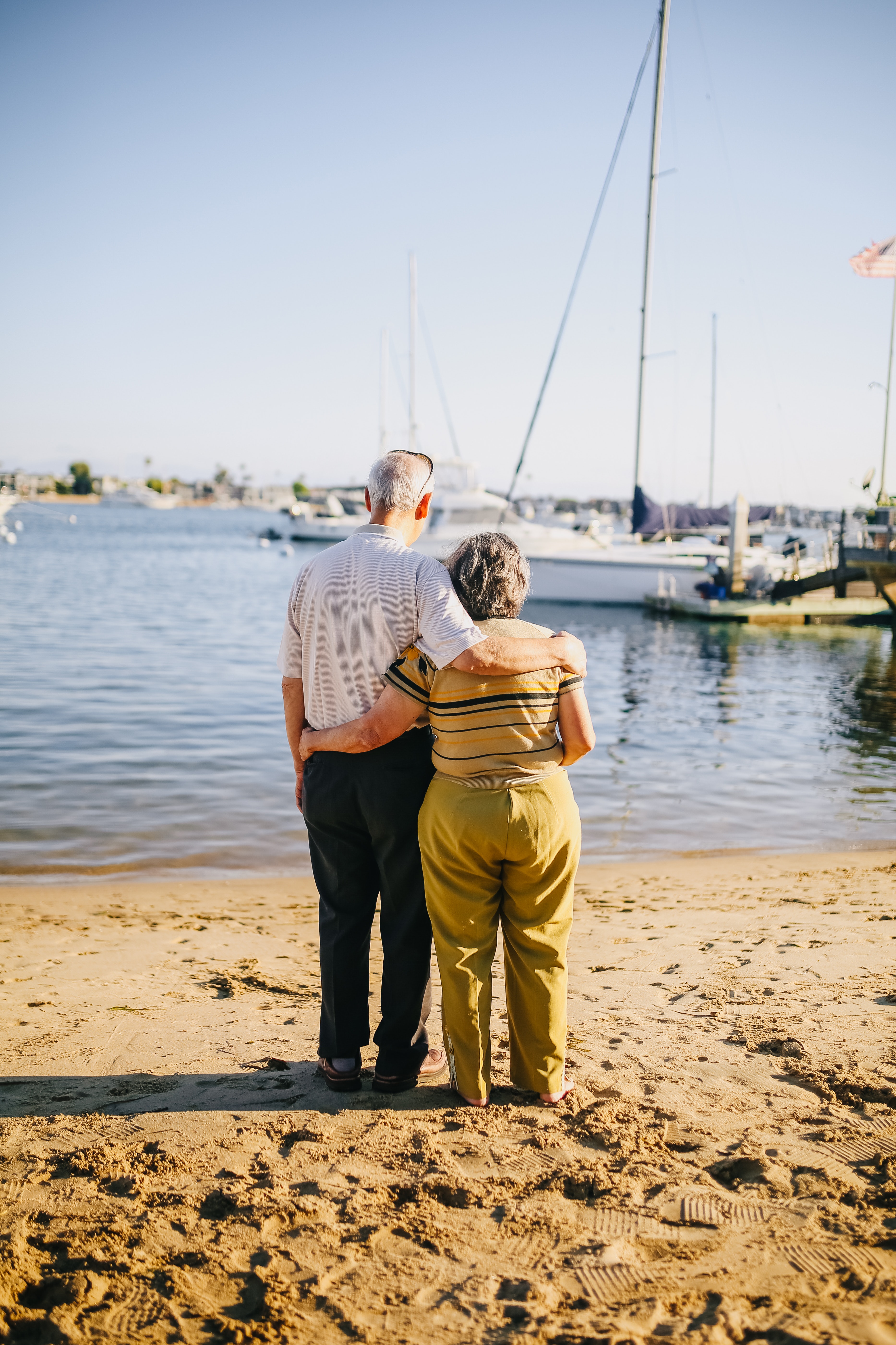 senior couple on a beach viewing sailboats